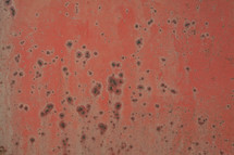 A red surface with spots of rust.