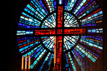 Circular stained glass window of the cross in a church.