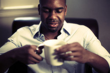 A man sitting down with a cup of coffee