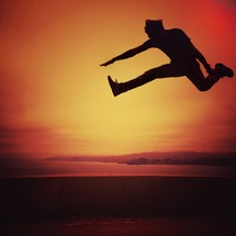 Man jumping in midair at sunset