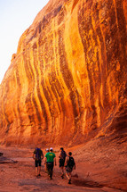 people hiking through a red rock canyon 