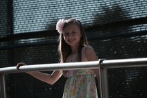 smiling girl with her hand on a railing 