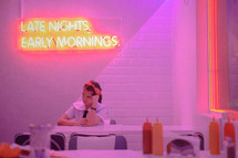 woman sitting in a dinner, late nights early mornings 