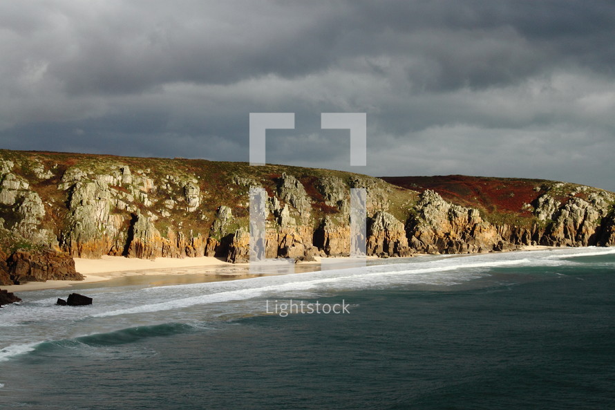 sea cliffs and the tide washing onto a beach