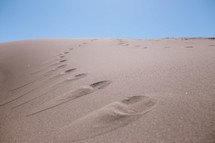 footprints on a sand dune 