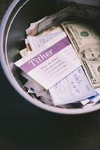 envelopes and cash in a bucket for offering