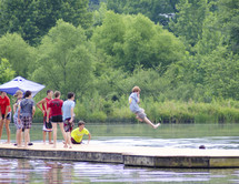 boys at summer camp jumping into lake water