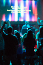teens with raised hands at a youth worship service 