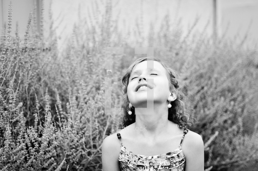 A little girl turns her face toward the heavens.