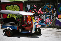pedicab and graffiti on a wall 
