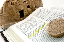 Bible open to The Gospel of Luke 24 in English and Hebrew with a Model of Jesus' Tomb and the stone which was rolled away.