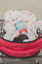 Infant in a stroller with a bottle.