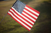 An American Flag being held up in a field