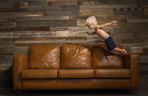 a child jumping onto a couch 