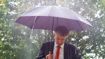 businessman standing in rain 