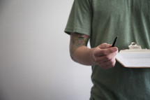 a man holding a clipboard and pen
