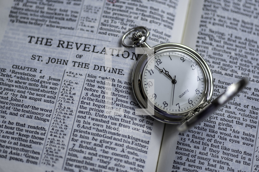 pocket watch on the pages of a Bible 