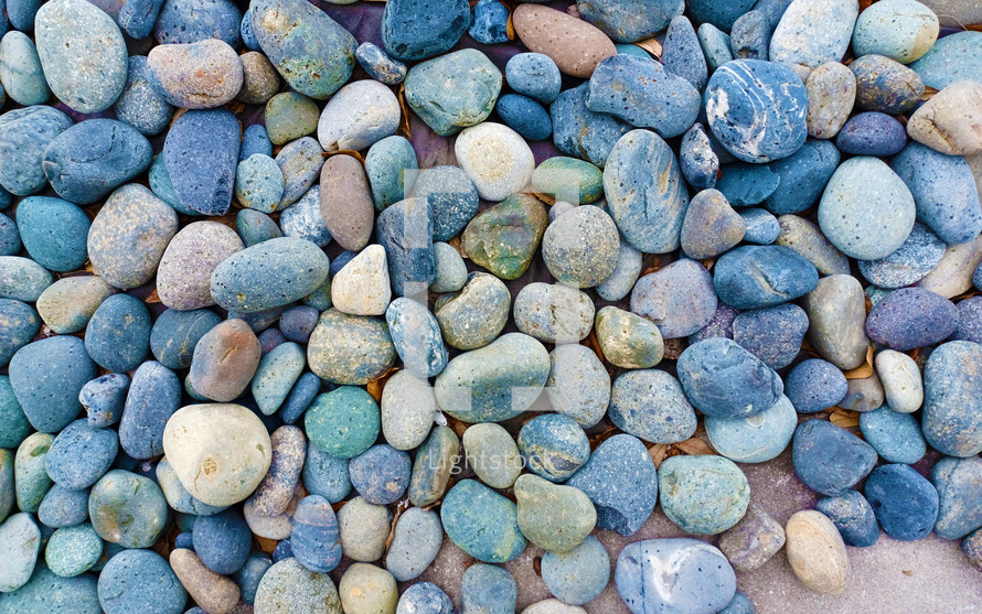 Stones and Rocks make up the path. A background image of blue, white and gray rocks used to line a yard or pathway