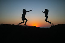 two women jumping across 