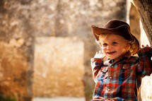 smiling toddler boy in a cowboy hat
