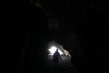 a person exploring a cave along a shore 