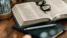 reading glasses on the pages of a Bible 
