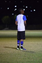 a young man standing on a soccer field ready to play 