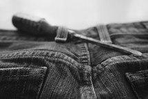 screwdriver in jeans belt loop 