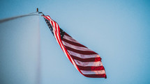 looking up at an American flag on a flagpole 