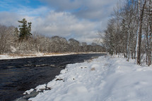 snow along a riverbank 