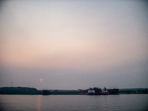 barges on the water at sunset 