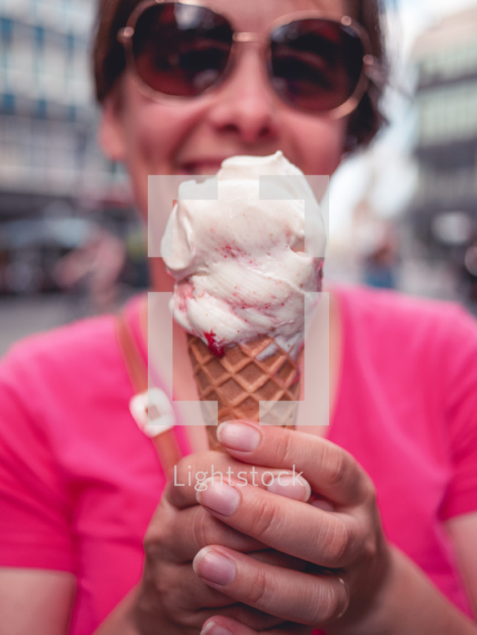 a woman in a pink shirt holding an ice-cream