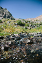 rocks in a creek surrounded by mountains 