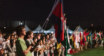 crowd holding flags of various nations 