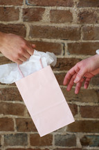 giving a pink gift bag 