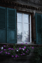 teal blue shutters and flowers in a window box