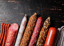 Assortment of various aromatic salami sausages. Against a dark background. High quality photo