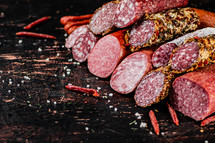 Assortment of various aromatic salami sausages. Against a dark background. High quality photo