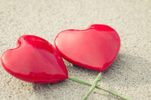 Solid red hearts with green stems on a textured background