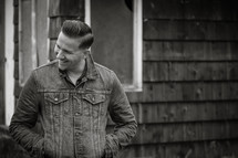 a man standing outdoors in a jean jacket 