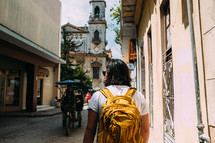 a man with a backpack walking on the narrow streets of Rome 