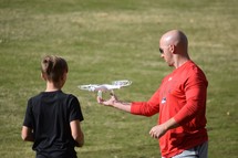 father and son flying a drone 