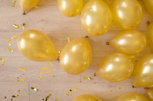 golden balloons and confetti on a wooden floor. preparation for a birthday or other party