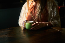 a woman in a sweater with a coffee mug 