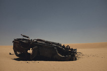burned out overturned car in a desert 