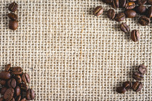 Bunch of Coffee beans laying on burlap fabric. Background voor coffee related products.