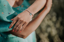 Female Hand With Silver Beads Bracelet And Blue Heart Charm. Turquoise Jewelry