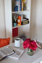 red roses in a vase and open Bible on a table 
