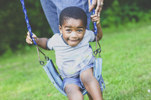 toddler boy on a swing 