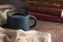 coffee cup and sweater with books 